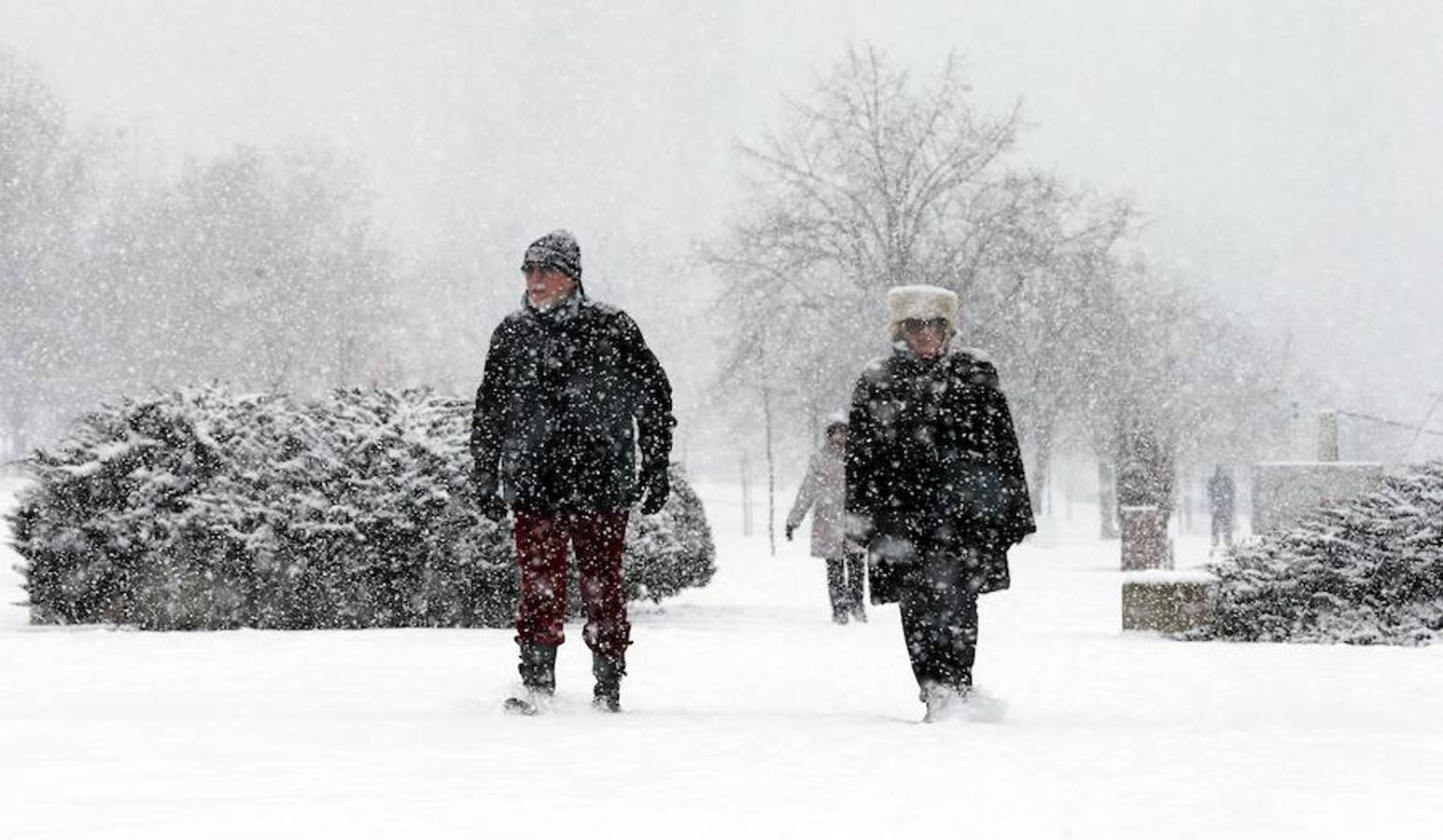 Varias personas caminan por la nieve en Belgrado. 