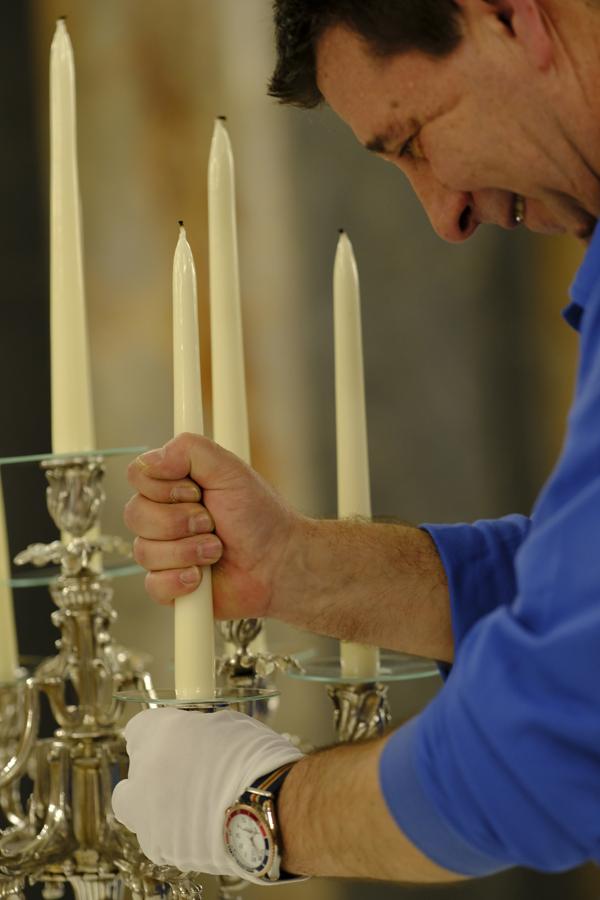 Velas con las mechas quemadas. Hay que colocar 80 velas en los ocho candelabros de plata. Las mechas se queman antes para facilitar después su encendido, ya que hay que hacerlo en un tiempo récord