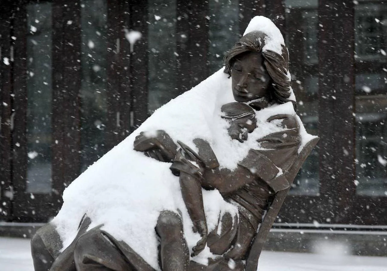 Estatua de una mujer que sostiene a un niño fuera de una galería de arte en Greenwich Avenue en Greenwich, Connecticut
