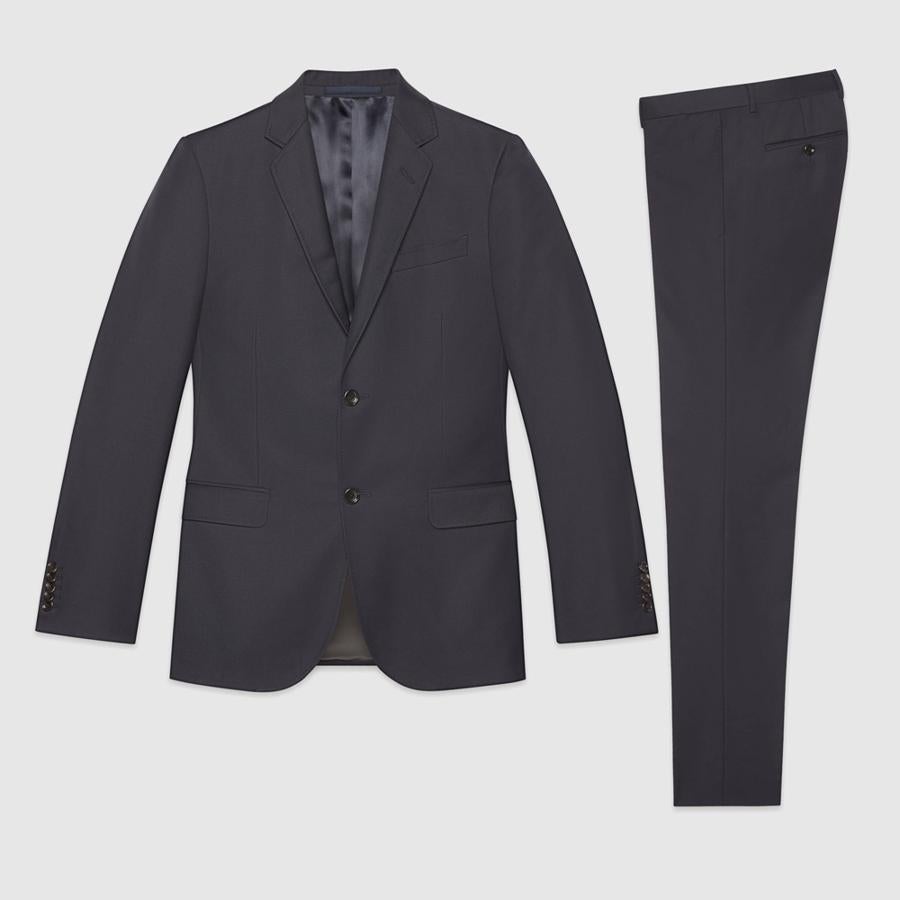 9. Traje de chaqueta. Posiblemente la pieza más elegante de tu armario debe ser sofisticada y versátil, si no eres un coleccionista de trajes, no arriesgues demasiado en ellos. Acertarás con colores neutros que podrás adaptar a infinidad de ocasiones. Traje de lana elástica en color azul marino (1.890€)