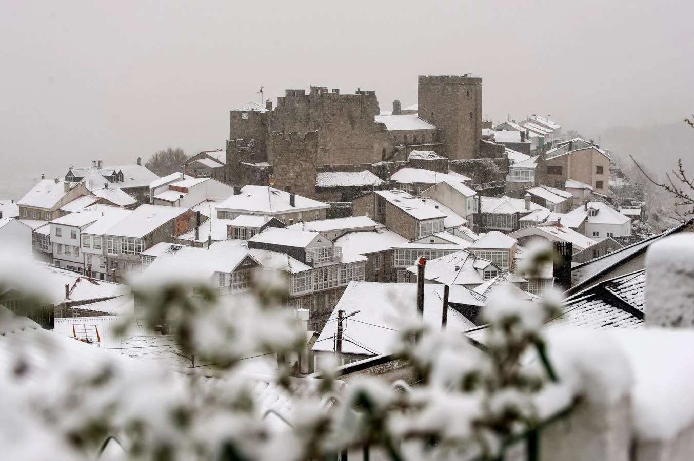 Vista general del pueblo de Castro Caldelas (Ourense) cubierto por la nieve.