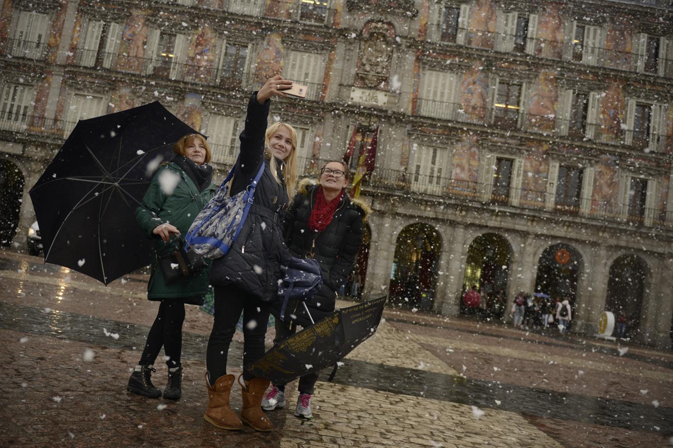 Tres mujeres se hacen un «selfie» en la Plaza Mayor de Madrid bajo la nieve