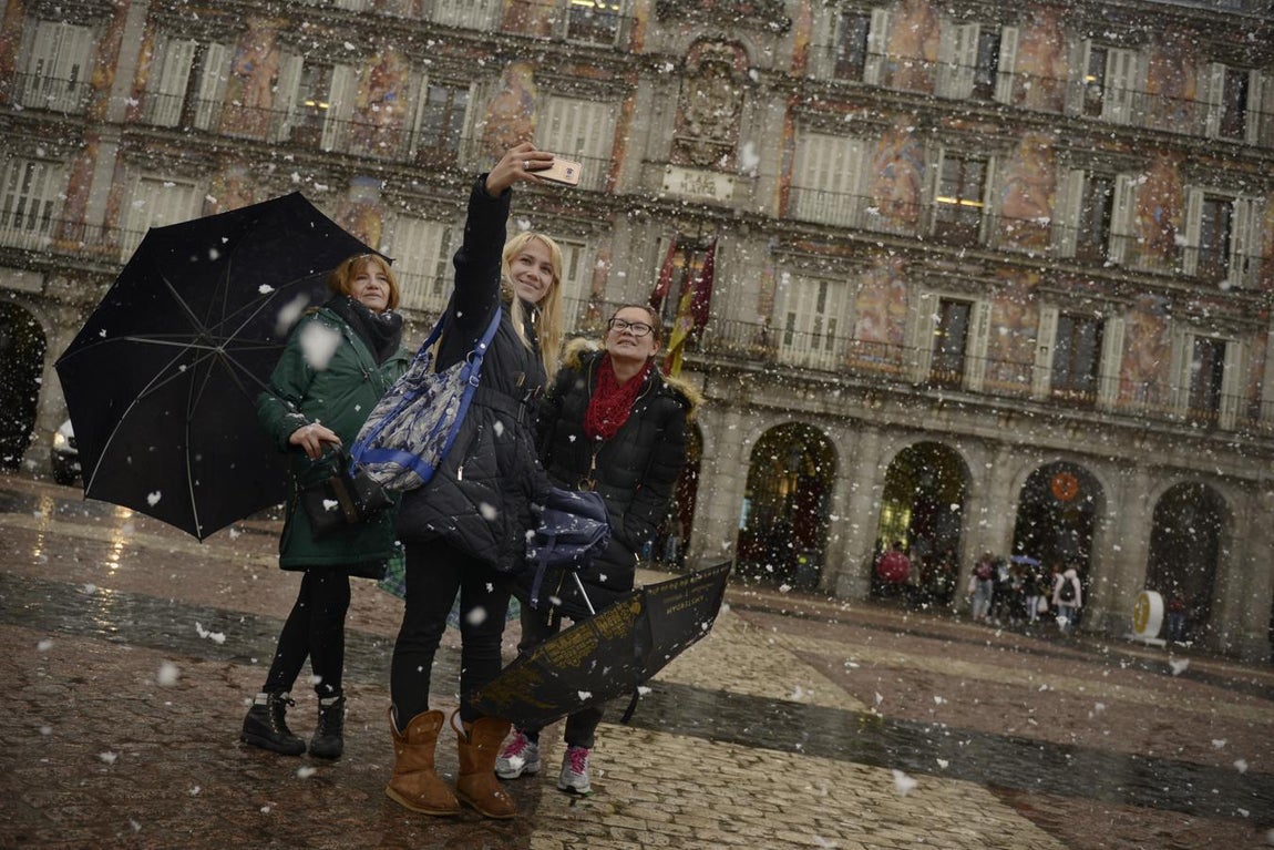 Tres mujeres se hacen un «selfie» en la Plaza Mayor de Madrid bajo la nieve. 