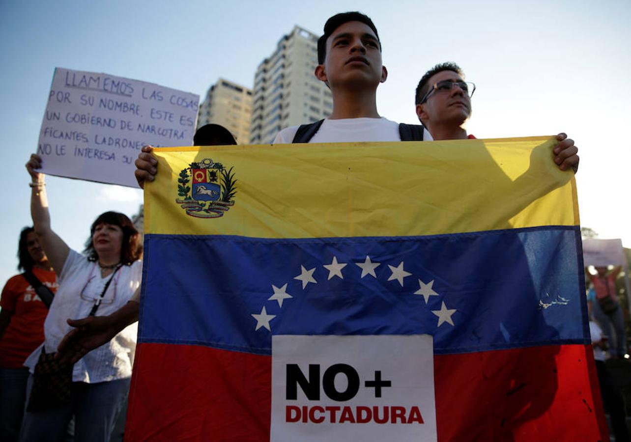 Un estudiante porta una bandera en la que se puede leer «no más dictadura» en una de las protestas organizadas en Caracas. 