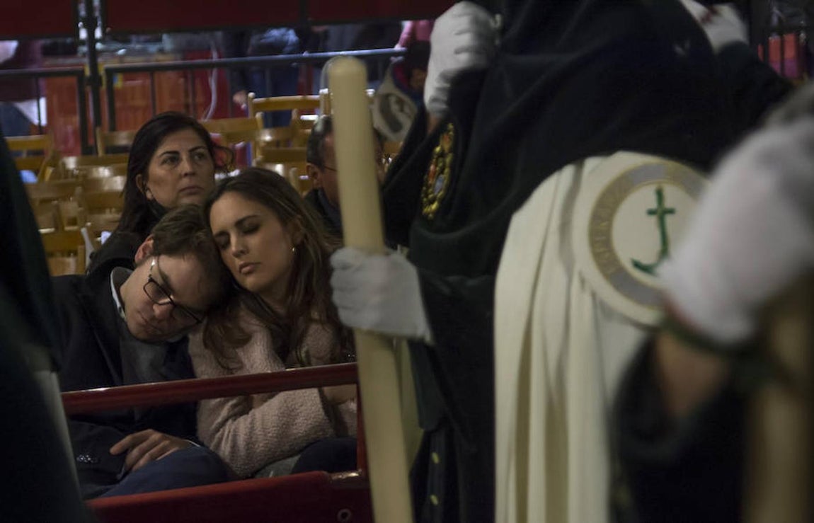 Una pareja duerme ante la procesión de la Esperanza. 