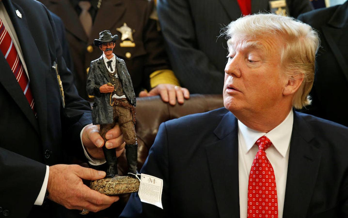 El presidente de los Estados Unidos, Donald Trump, recibe una estatuilla de un sheriff durante una reunión con los sheriffs del condado en la Casa Blanca en Washington