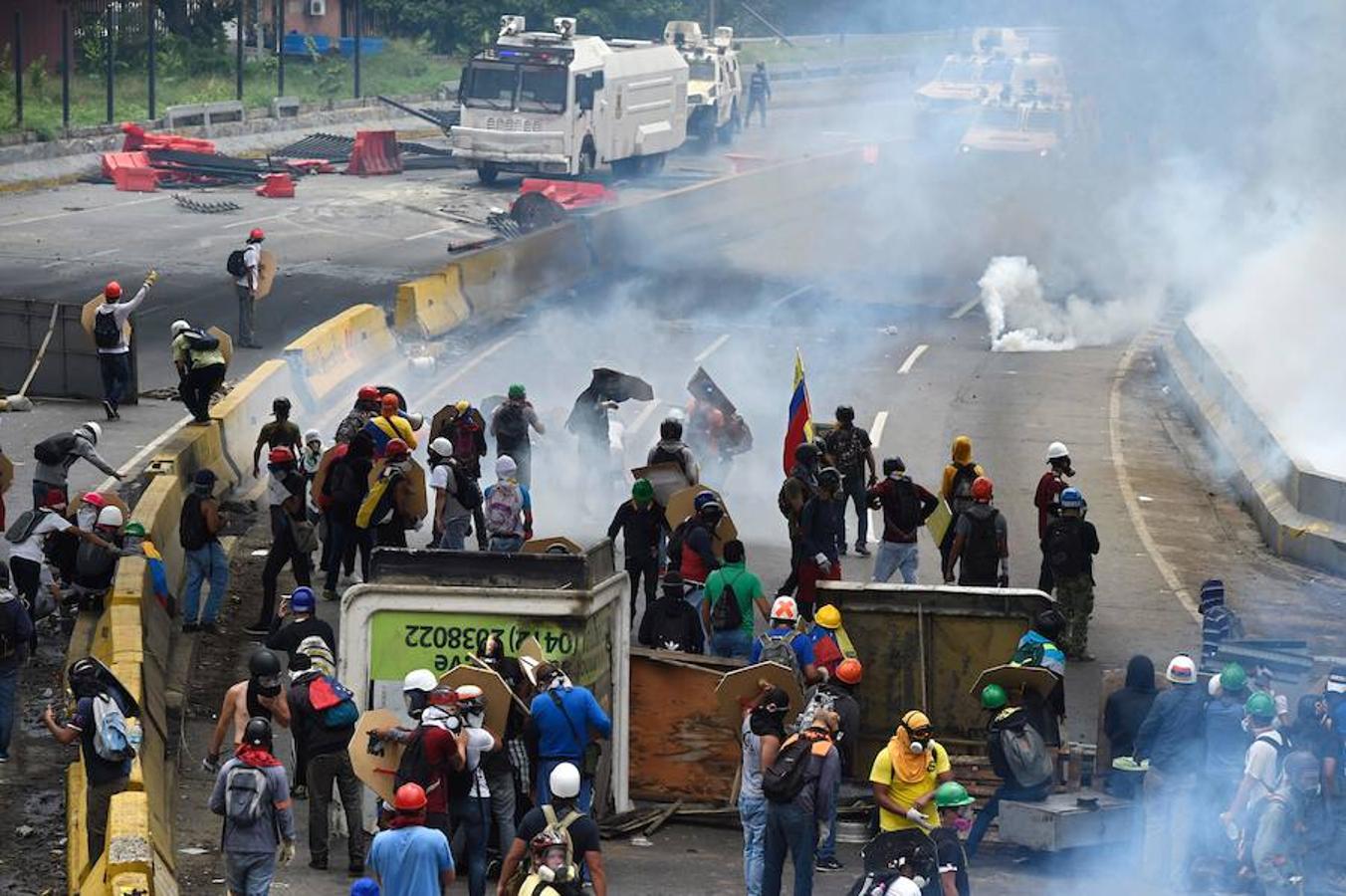 Oposición y policía pelean en plena carretera. La oposición enfurecida protesta en las calles contra el plan del presidente Nicolás Maduro de reescribir la constitución y acusarlo de esquivar las elecciones para aferrarse al poder a pesar de los disturbios mortales.