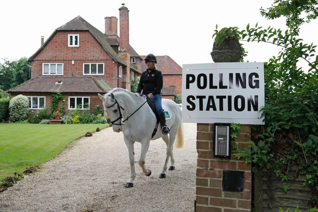 Mesa de votación en una residencia privada. Sophie Allison, montada en su caballo Splash, sale de la entrada de una residencia privada, establecida como una sala de votación, cerca de Reading, al oeste de Londres.
