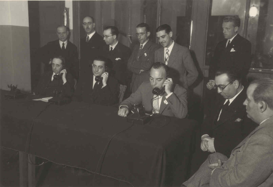 Conferencia desde la central de Toledo con Toledo de Ohío el 5 de julio de 1936. En la mesa, de izquierda a derecha y con auriculares, el embajador C. Bowers, el alcalde G. Perezagua y Germán Erausquin. FOTO ARCHIVO FUNDACION TELEFÓNICA. 
