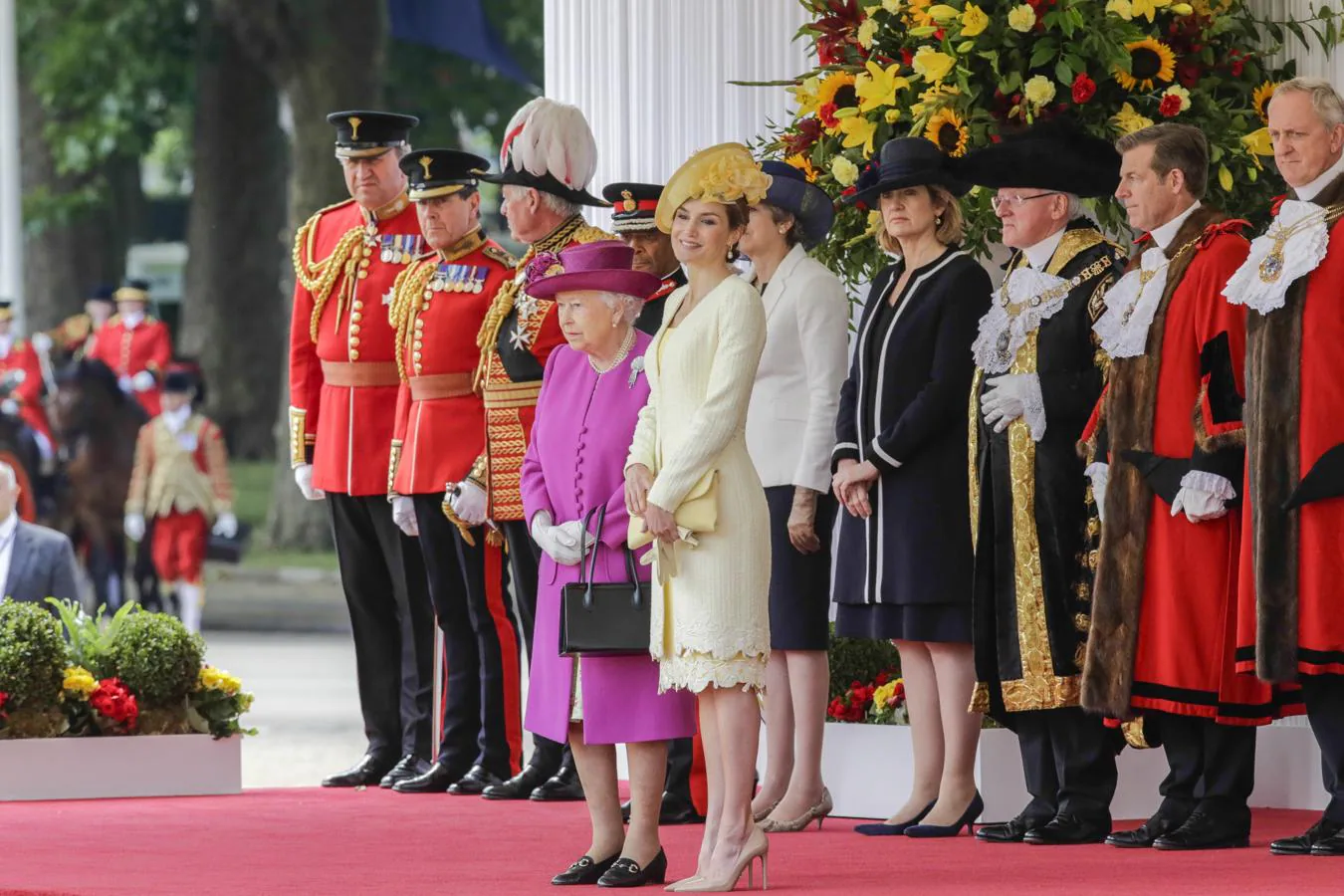 La Reina ha apostado por un abrigo en tweed de verano adornado con una cinta de macramé amarillo hielo. 
