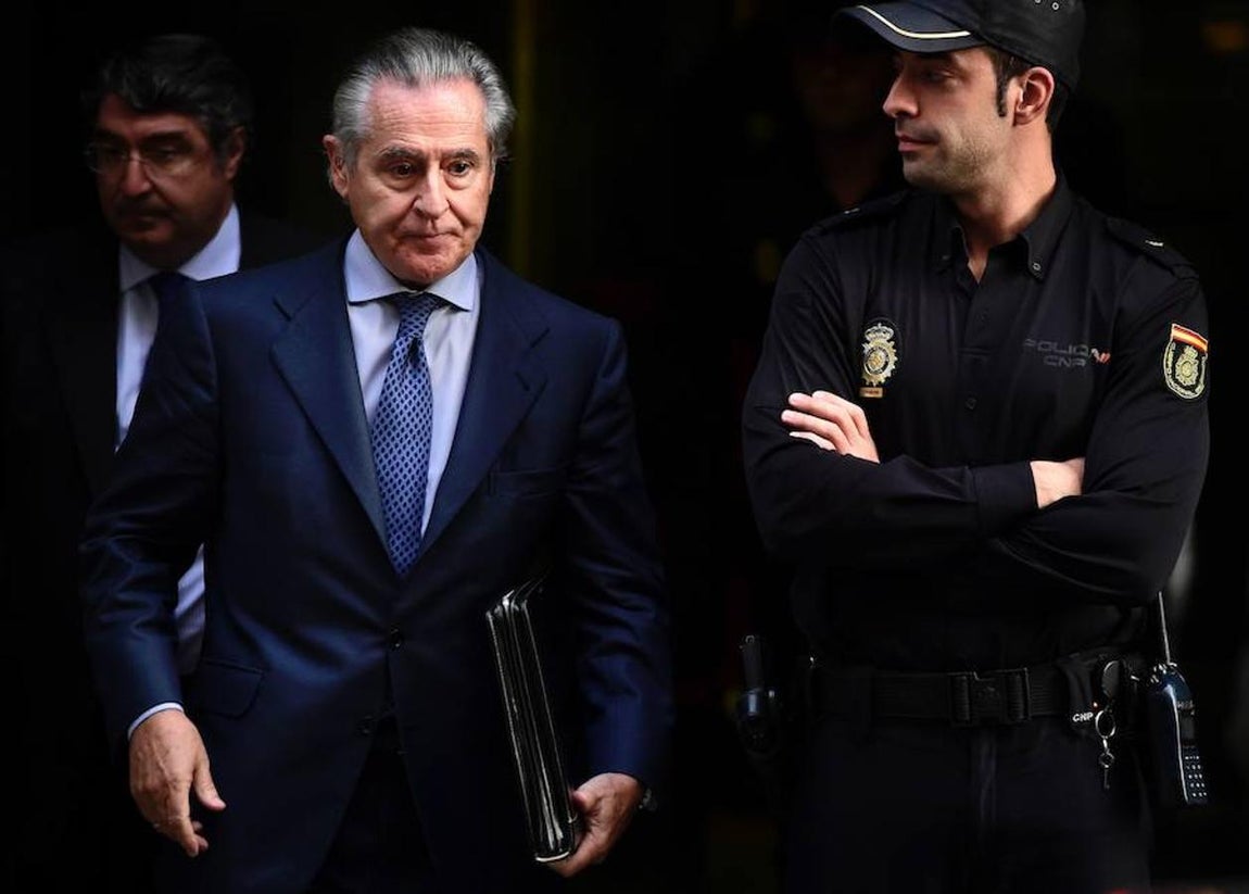 Miguel Blesa al lado de un Policía Nacional. 