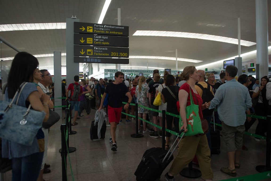 Un pasajero consigue hacerse paso en el «carril rápido», que también ha sufrido fuertes aglomeraciones y colas de espera en El Prat. 