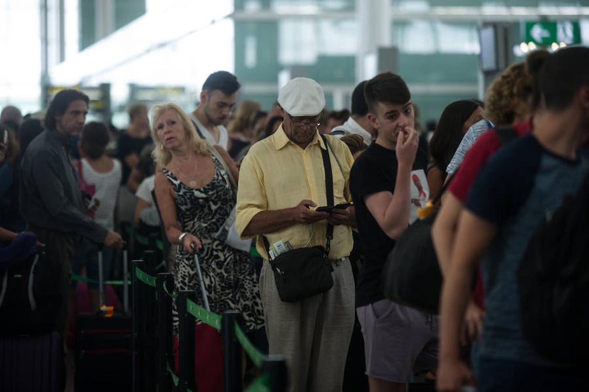 Imagen de una de las largas colas que se han formado en el aeropuerto de El Prat. 