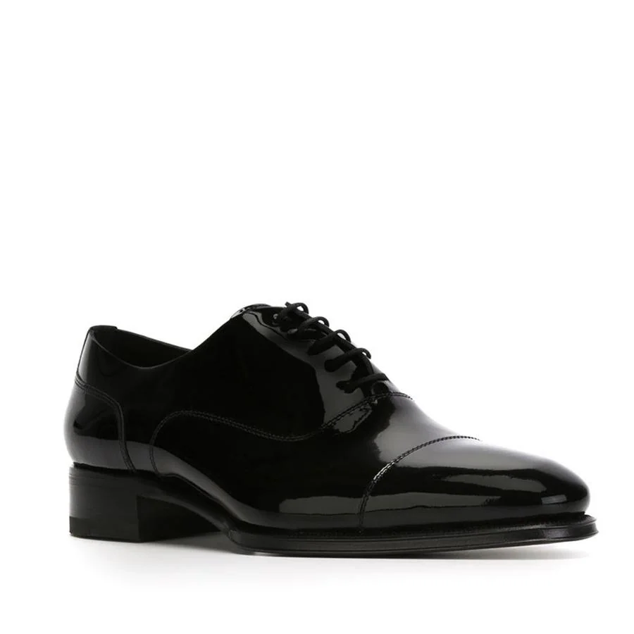 Zapatos estilo oxford con cordones clásicos de charol negros (495 €).