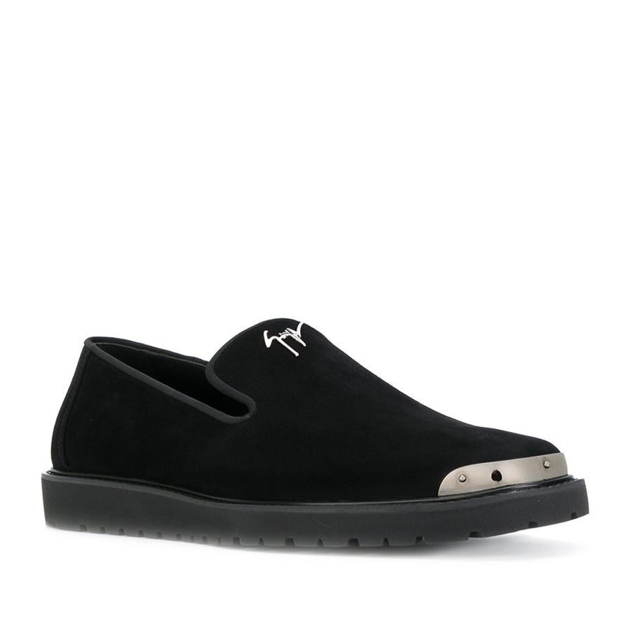 Slippers modelo Kent en piel de color negro con detalle plateado en la punta (625 €).