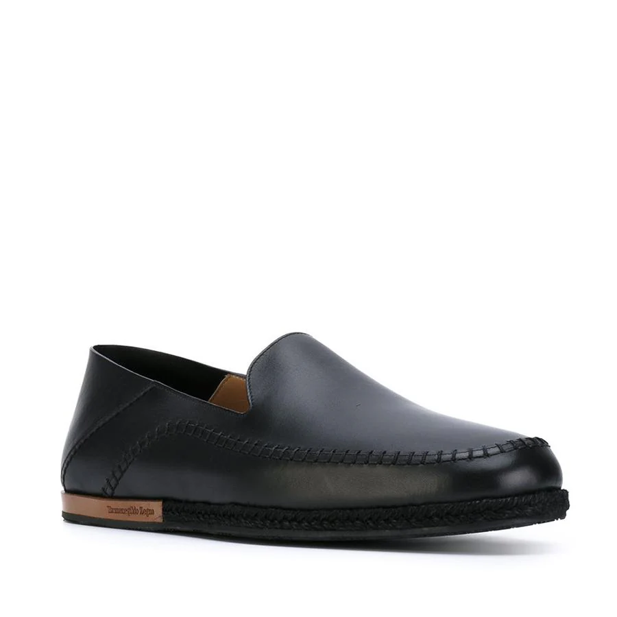 Zapatos slippers en piel negros con costuras (410 €).