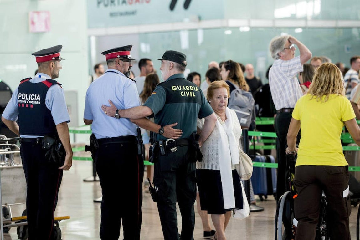 La Guardia Civil custodian los accesos a las puertas de embarque en el aeropuerto de Barcelona. 