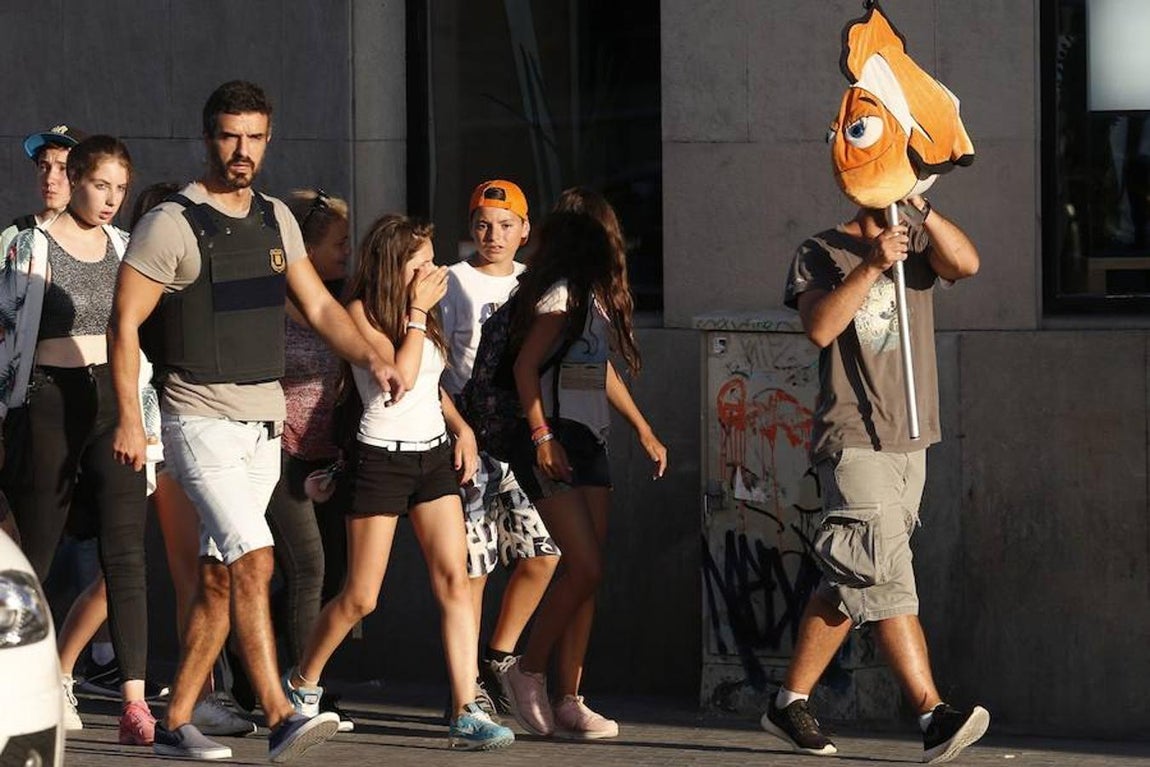 Un policía de paisano procede a sacar a unos jóvenes de la zona acordonada. 