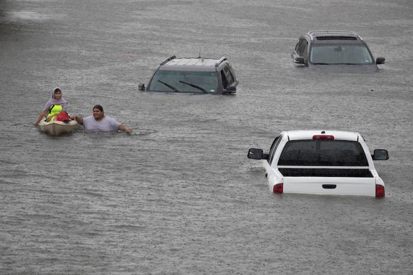 Un hombre rescata a una mujer que estaba atrapada por las inundaciones. 