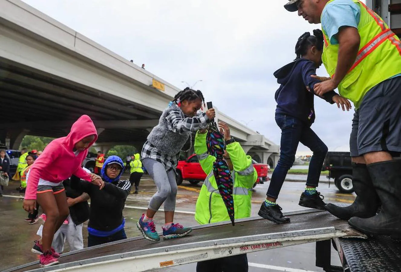 Tres niñas suben a un vehículo tras ser rescatadas de su barrio inundado después del paso del huracán Harvey en Houston, Texas. 
