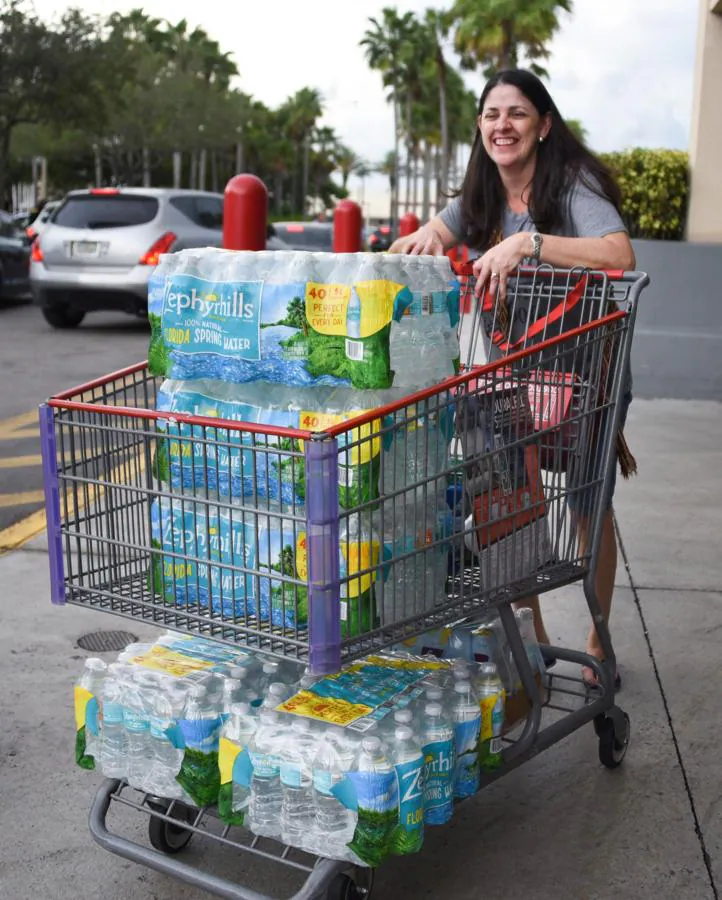 Una mujer posa en North Miami, Florida, con sus provisiones de agua compradas ante la llegada del huracán Irma. 