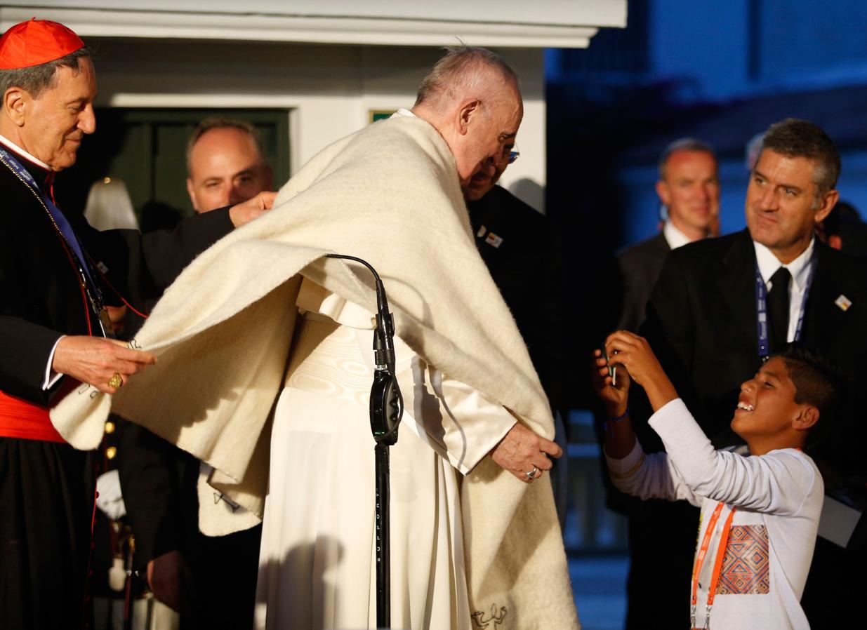 El Papa Francisco recibe un regalo de un niño en Bogotá. 