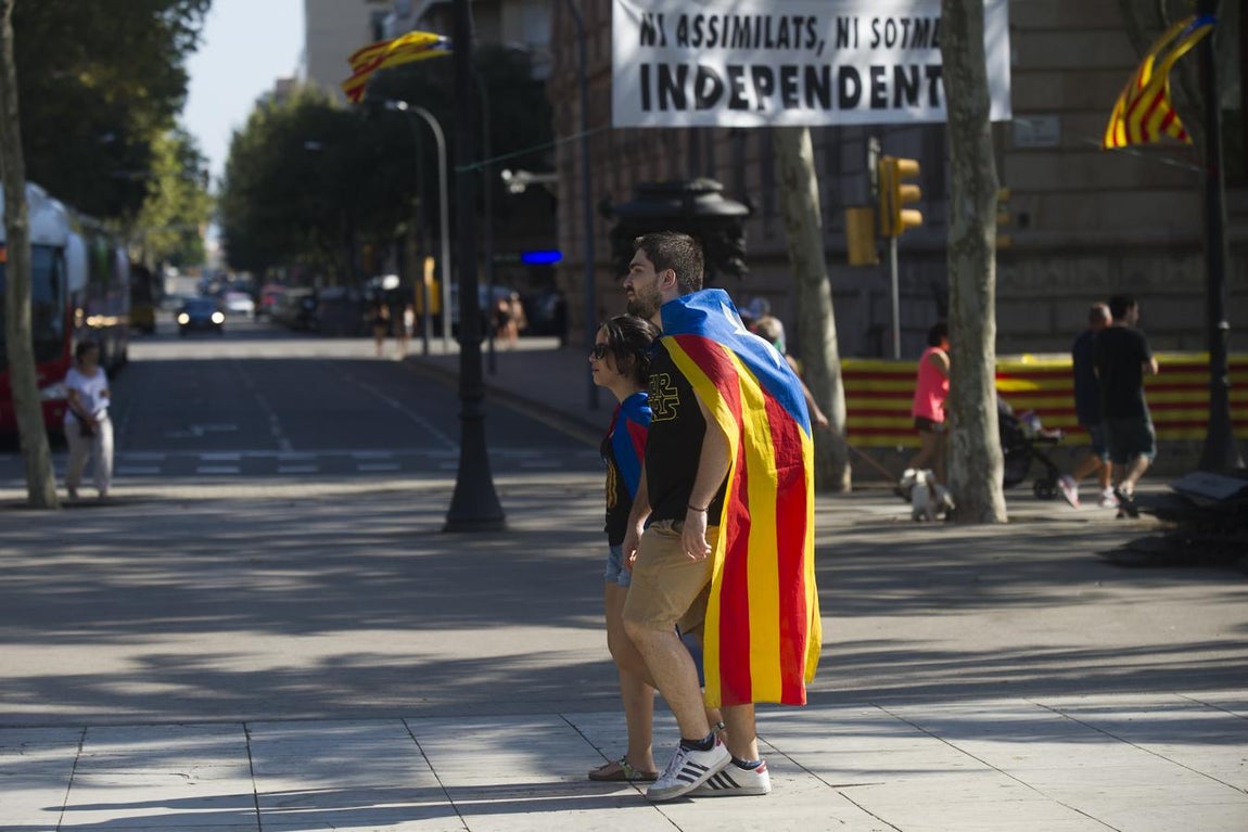 Dos jóvenes, con la estelada a modo de capa, en las calles de Barcelona durante la Diada de 2016. 