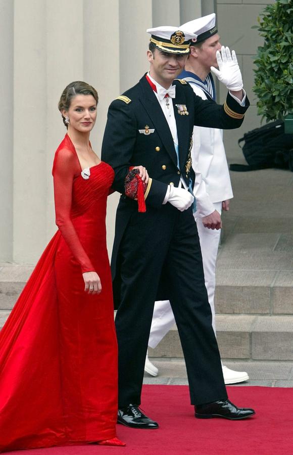 De rojo pasión. Para las ocasiones importantes, Doña Letizia suele decantarse por el rojo, como en la boda de Federico de Dinamarca y Mary Donaldson en la catedral de Nuestra Señora de Copenhague, en 2004. Escogió un elegante vestido ceñido de un rojo intenso y con un escote en forma de trapecio, de Lorenzo Caprile