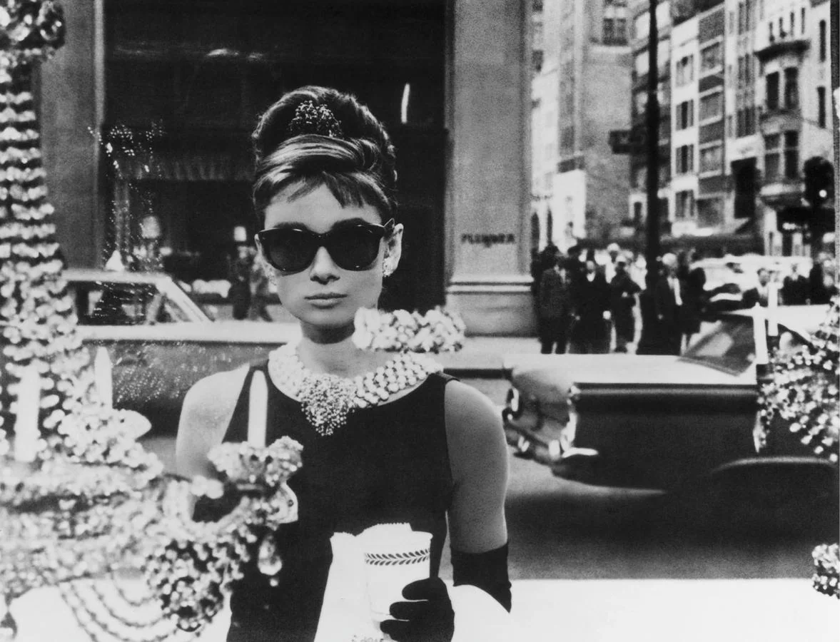 El vestido de Audrey Hepburn en «Desayuno con diamantes». La escena en la que una ingenua Holly Golightly contempla el escaparate de la joyería Tiffany's después de comerse un croiessant convirtió a este vestido en un objeto de culto que permanecería cosido siempre al recuerdo de Audrey Hepburn en la memoria colectiva