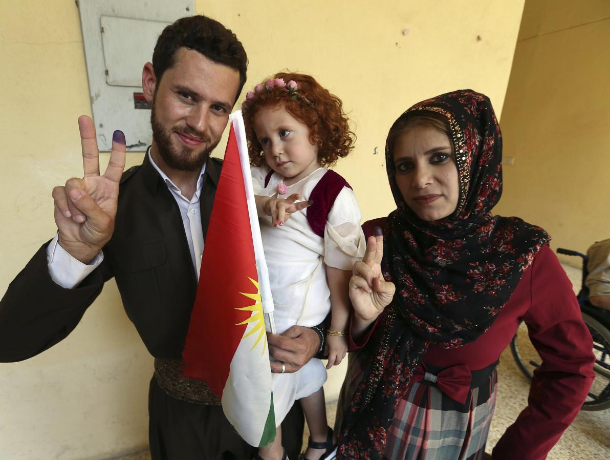 Una familia kurda muestra sus pulgares manchados de tinta tras depositar su voto. 