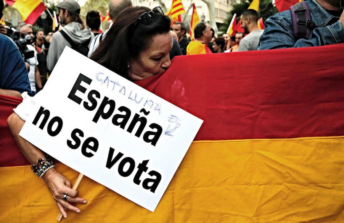 Una participante besa la bandera española durante la manifestación convocada por Movimiento Cívico de España y Catalanes, hoy en la plaza Urquinaona, en Barcelona, con el lema «Catalunya es Espanya. Democracia, futuro y libertad».. 