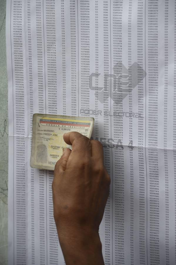Un ciudadano venezolano busca su nombre en el censo electoral. AFP