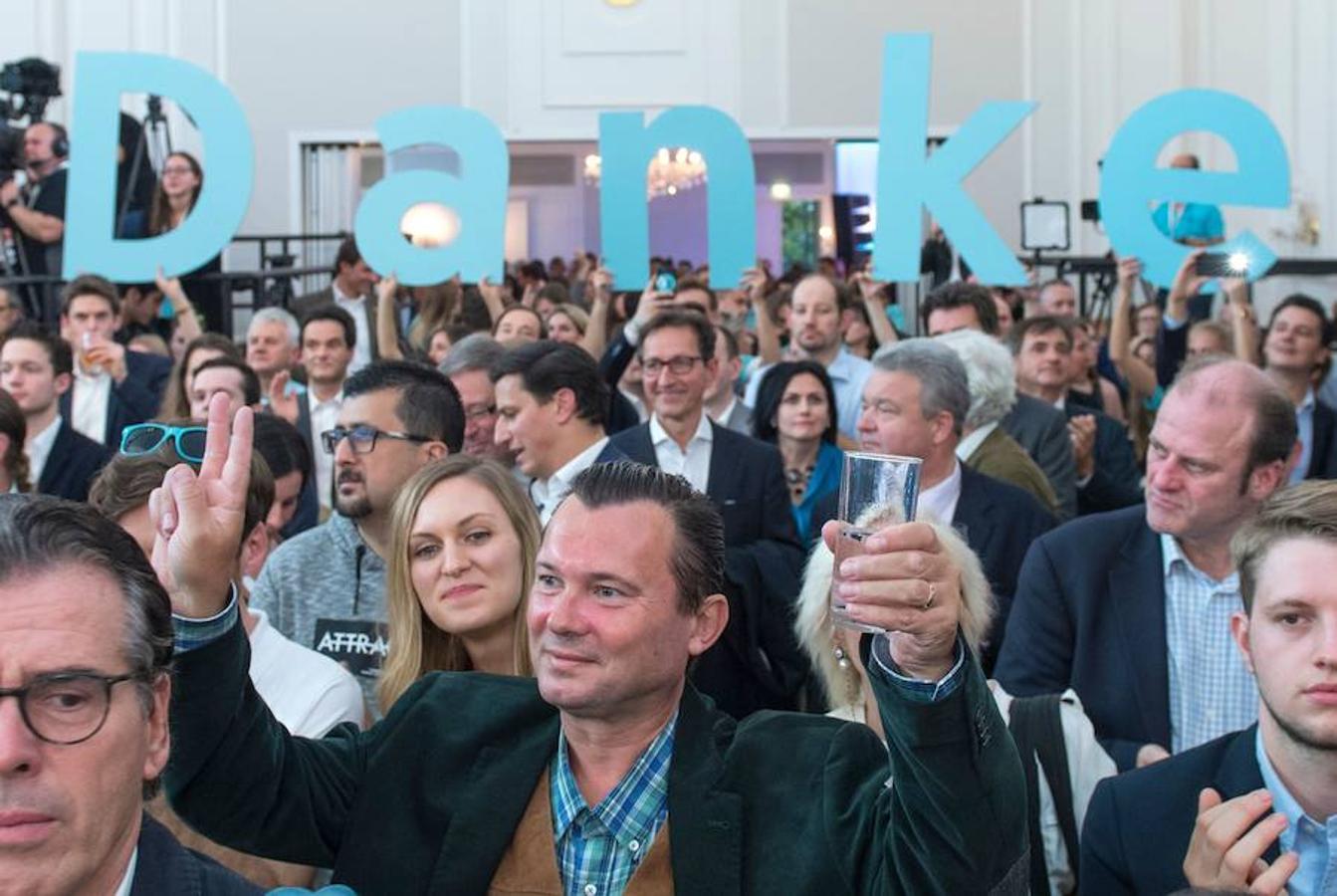 Los simpatizantes del Ministro de Asuntos Exteriores de Austria y líder del Partido Popular de centro-derecha de Austria (OeVP), Sebastian Kurz, reaccionan después de que se publicaron los primeros resultados durante el evento electoral del partido. 