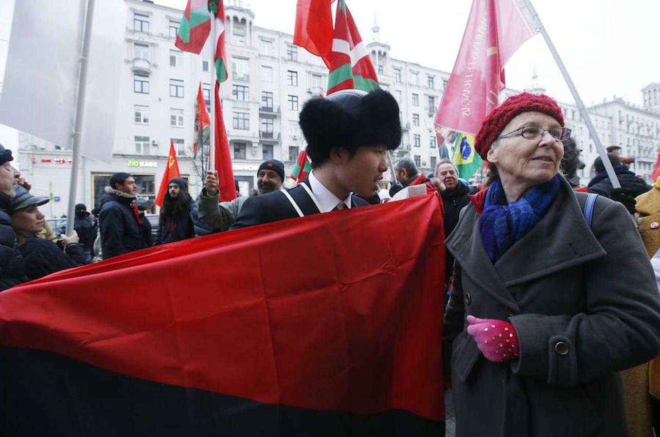 Dos miembros de las delegaciones china y francesa marchan juntosdurante un acto que conmemora el centenario de la Revolución Bolchevique en Moscú. 