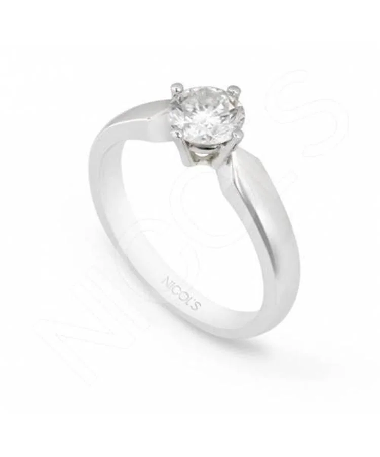 Anillo Marie Twisted. El anillo solitario de pedida de oro blanco y diamantes está inspirado en los años 60's. Tiene piedra central en forma redonda engastada en cuatro garras y brazo de cuerpo plano alto y en disminución