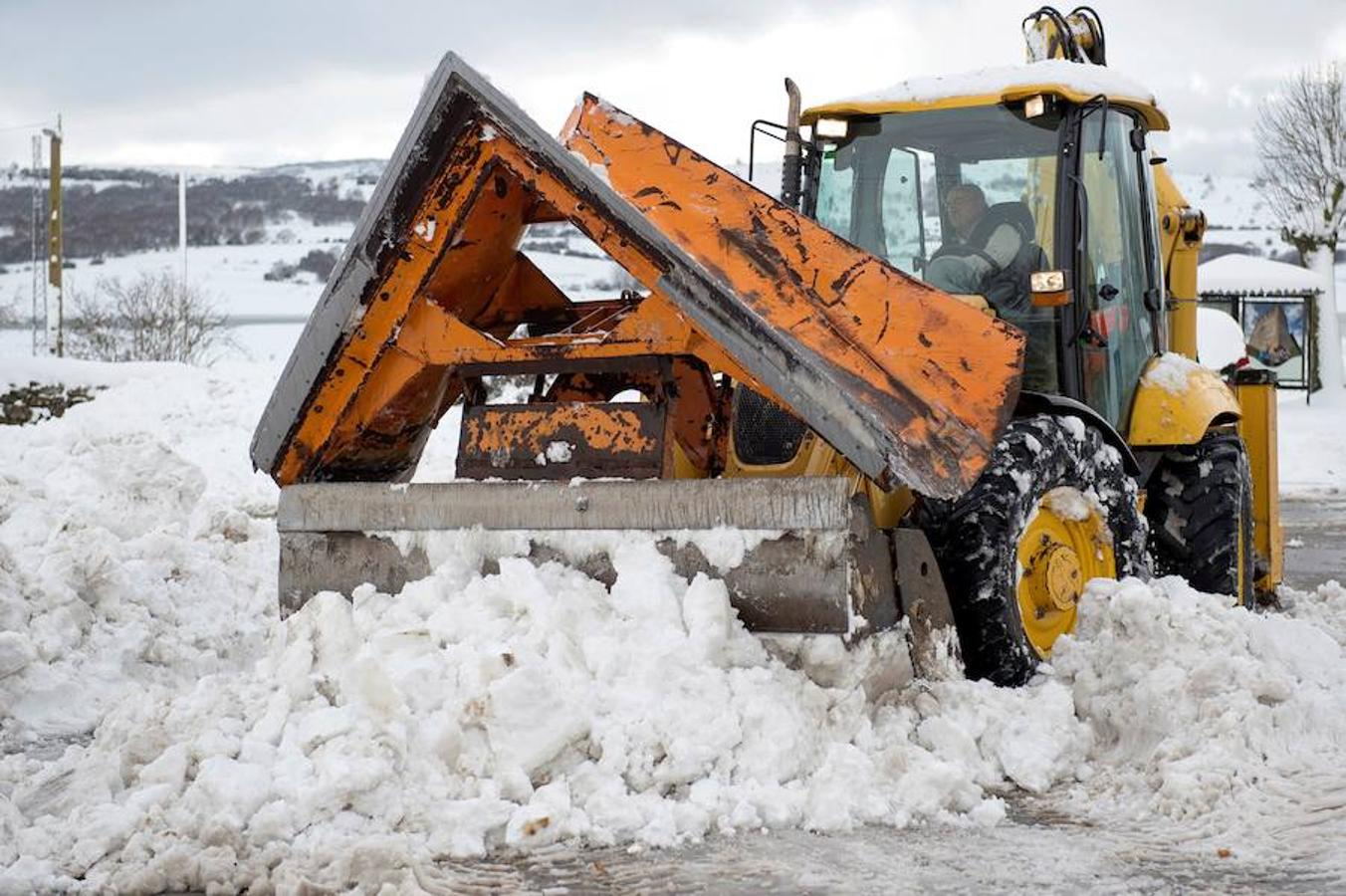 Un hombre quita nieve en la calle para poder sacar el coche, en la localidad cántabra de Bolmir. 