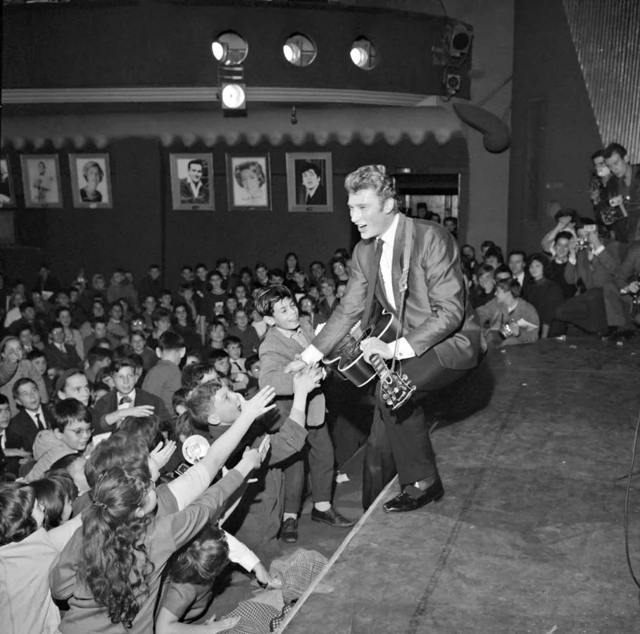 Johnny Hallyday saluda a sus seguidores durante un concierto de 1962. 