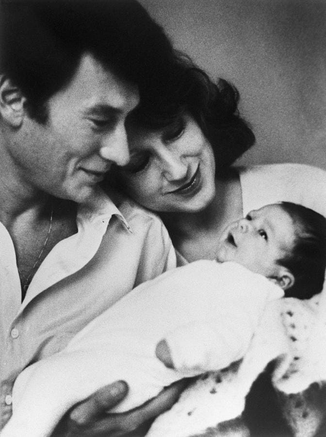 Johnny Hallyday muestra a su recién nacida hija Laura, el 1 de diciembre de 1983, junto a la actriz Nathalie Baye. 