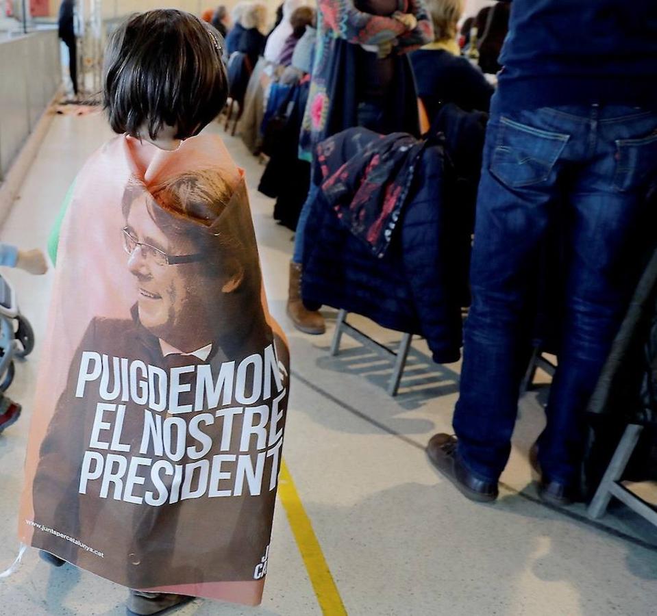 Un niña con una foto del expresidente de la Generalitat Carles Puigdemont a modo de capa, durante la «Butifarrada solidaria». 
