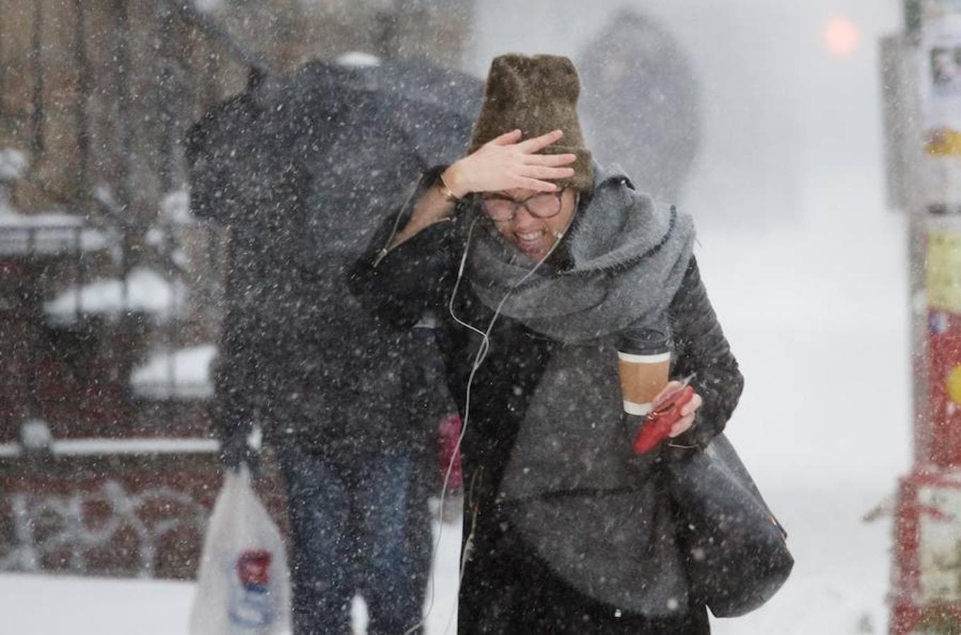 Una mujer se cubre la cara para protegerse durante la tormenta de viento y nieve en el neoyorquino barrio de Brooklyn.. 
