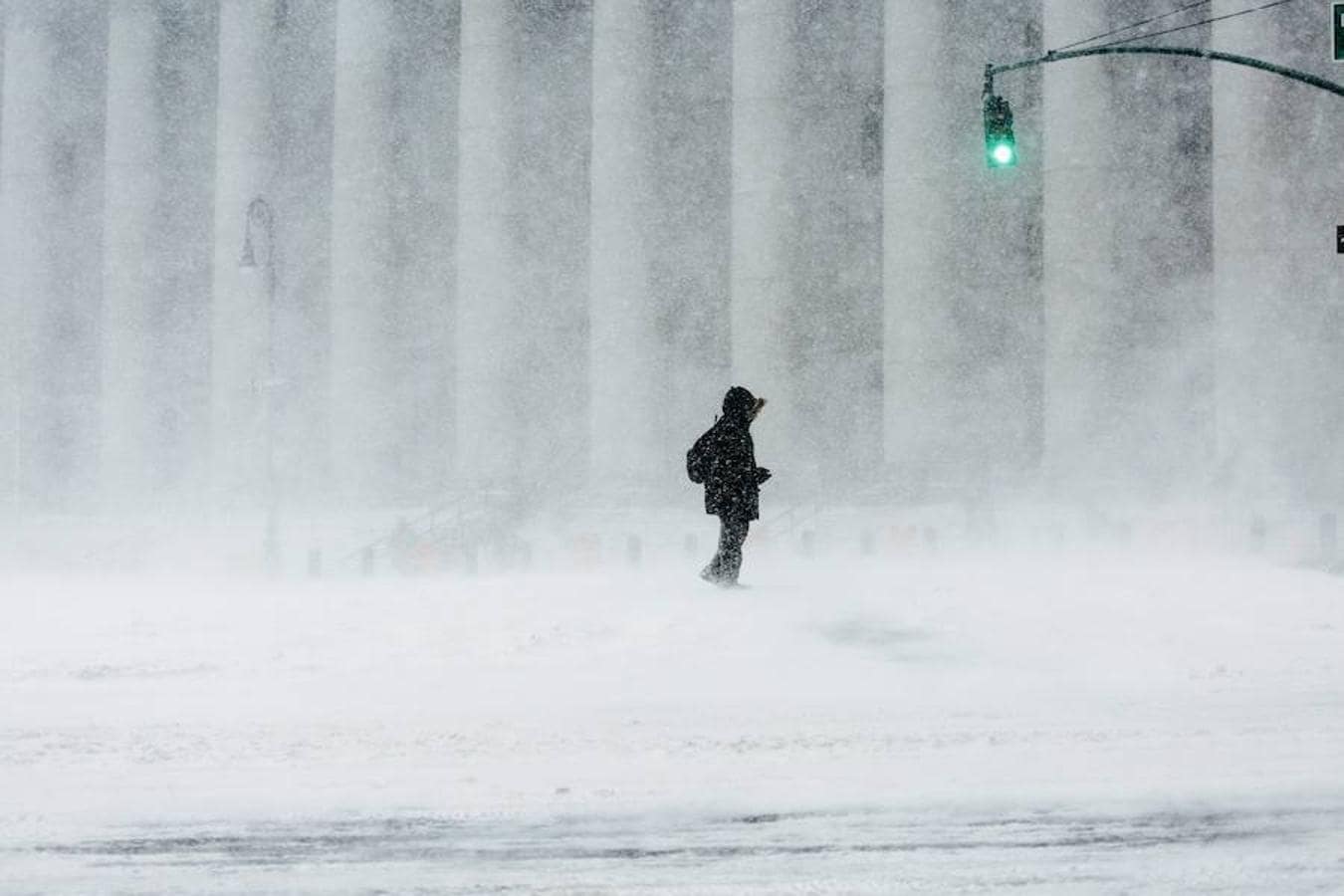 Un hombre camina bajo la nieve en Nueva York.. 
