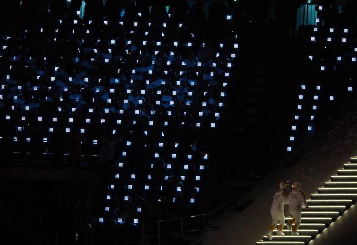 Dos atletas han dado el último relevo de la antorcha olímpica antes de encender el pebetero. 