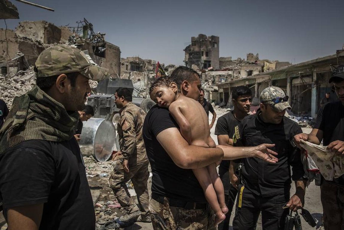 La instantánea del fotógrafo Ivor Prickett para el New York Times que muestra a un niño en brazos de un hombre, sospechoso de ser militante del Daesh, que intenta salir de la última zona controlada por el Daesh en Mosul (Irak) el 12 de julio de 2012. Los soldados sospechaban que el hombre usaba al niño como escudo humano para conseguir abandonar el lugar ya que no sabía su nombre y alegaba que lo había abandonado a sus suerte en la calle. Uno de los soldados finalmente adoptó al niño del que no se sabía nada y no hablaba. 