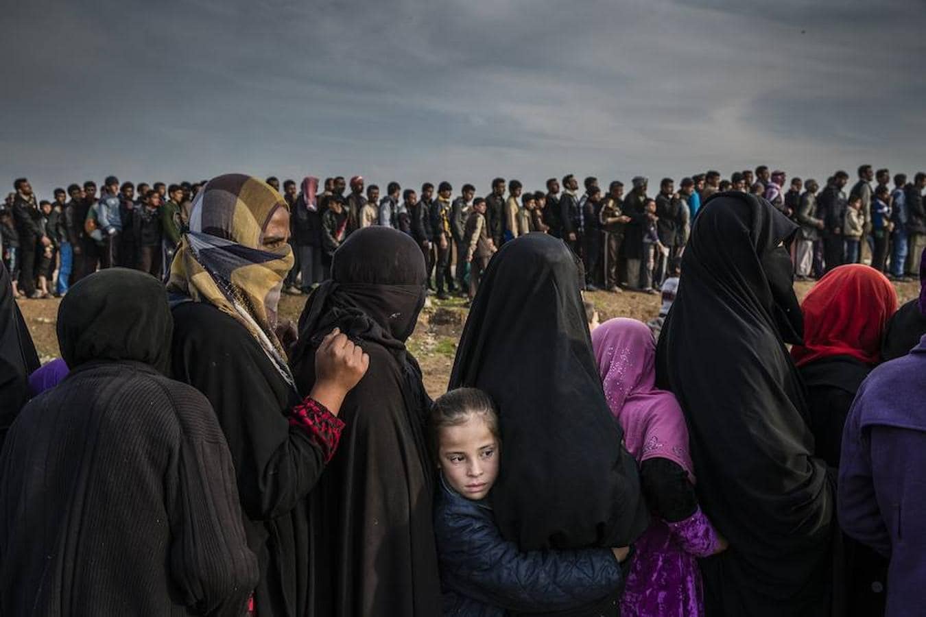 La obra del fotógrafo británico Ivor Prickett para el New York Times tomada el 15 de marzo de 2017 que muestra a civiles que quedaron en el este de Mosul durante la batalla para recuperar la ciudad, mientras hacen cola para recibir medicamentos en el barrio de Mamun, en Mosul (Irak). 