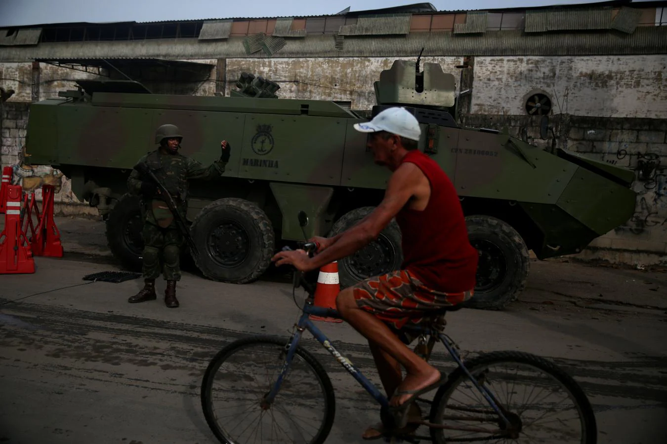 Un ciclista pasa frente a uno de los tanques del ejército de Brasil, desde el pasado miércoles presentes en las favelas. 