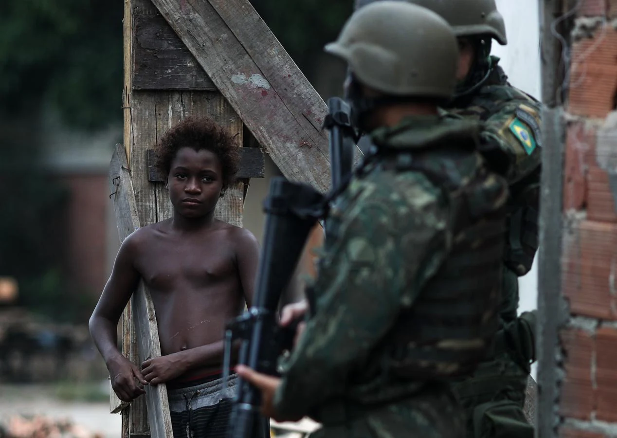 Un joven observa a las autoridades que vigilan desde ayer las favelas de Río de Janeiro. 