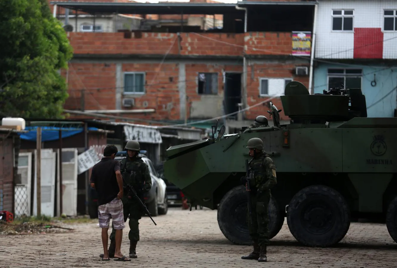 Militares conversan con un hombre en la favela de Kelson, en Río de Janeiro. 