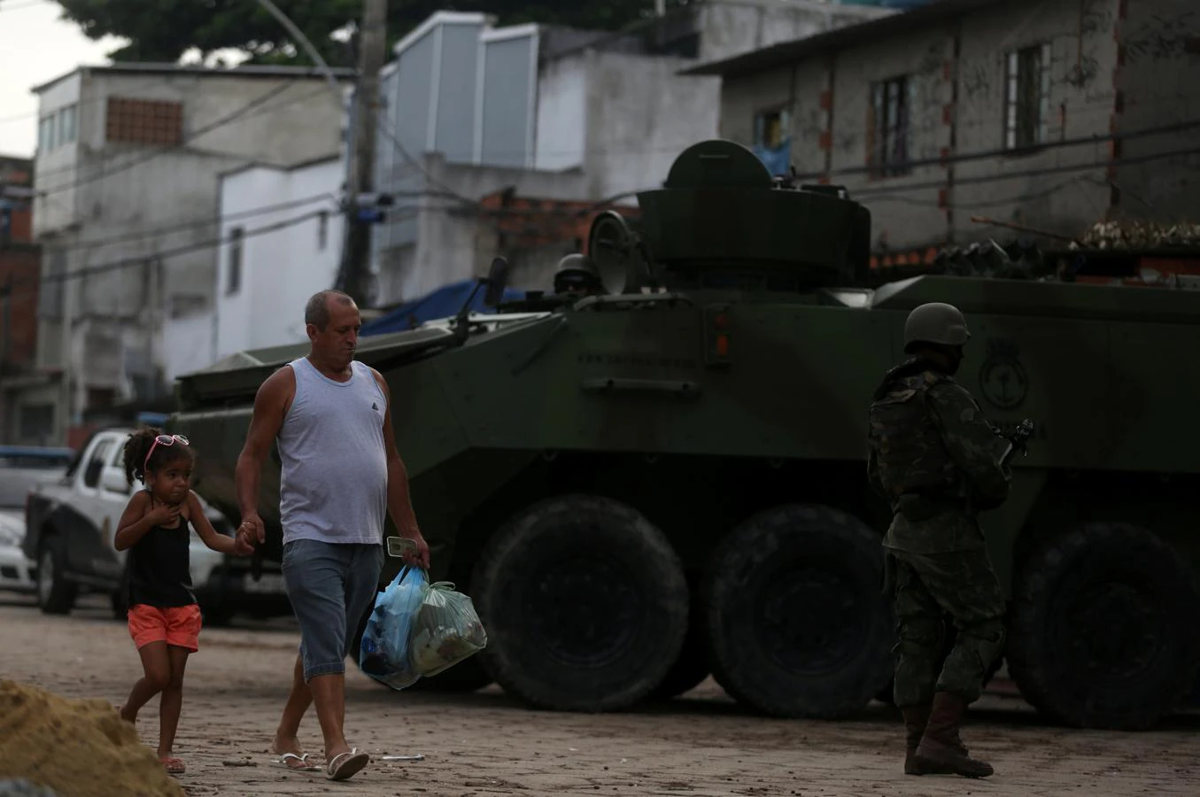 Un hombre y una niña pasan frente a un tanque en la favela de Kelson, en Río de Janeiro. 