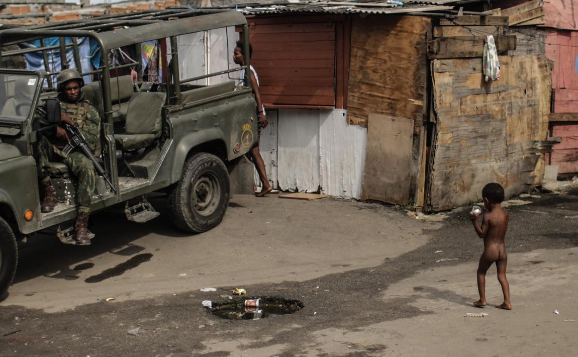 Un niño juega frente a uno de los furgones desplegados por ejército desde el pasado martes en Río de Janeiro. 