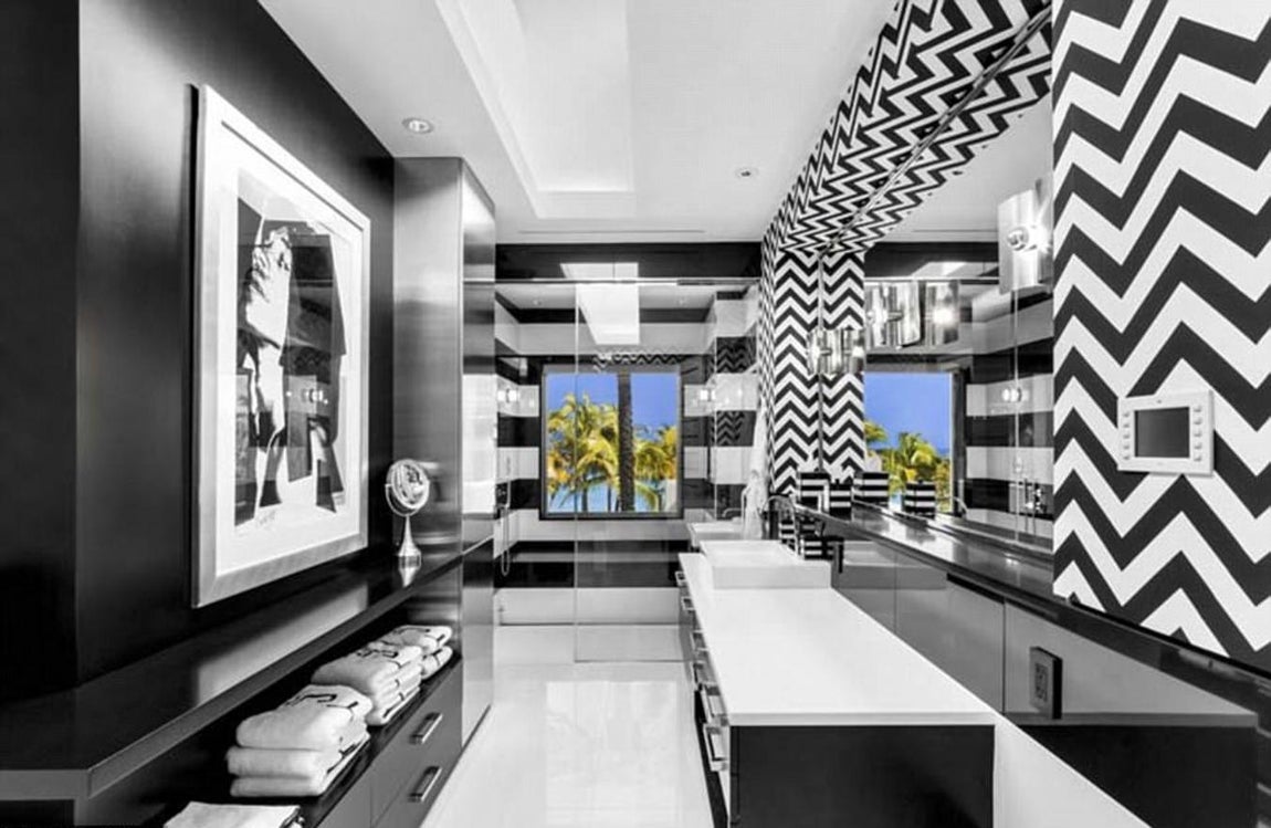 Cuarto de baño principal. Lo preside una serigrafía hecha por Andy Warhol de Mick Jagger. La pared, llena de motivos geométricos en blanco y negro está revestida con un Martyn Lawrence Bullard. Las baldosas de vidrio del suelo son de WalkOn Tile y las piezas del baño son creaciones de Kallista